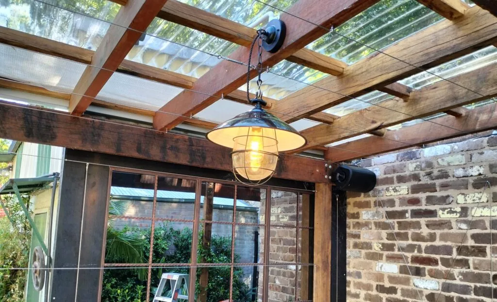 a antique pendant light hanging in pergola